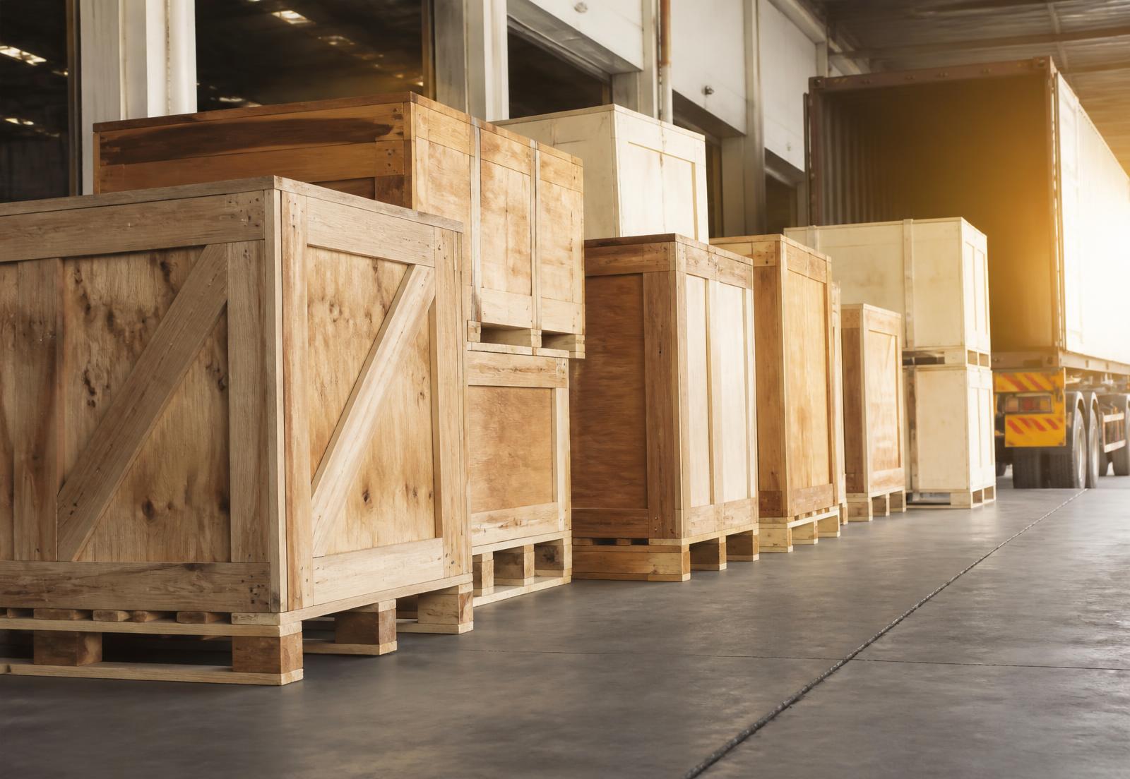 Custom wooden crates and pallets staged on a loading dock beside a trailer